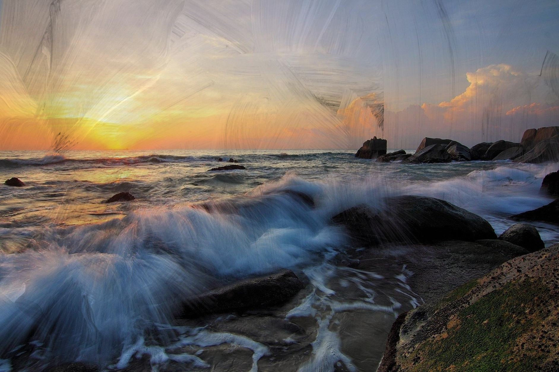Waves breaking on rocks at sunset